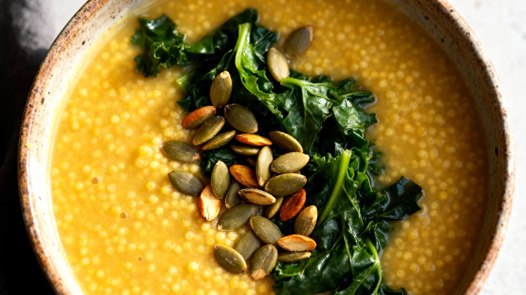 Zuppa di miglio con verdure amare e semi di zucca"